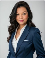 A professional headshot of a woman with long, dark, wavy hair.
